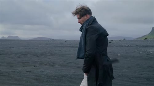 A Young Man Stands at Reynisfjara Black Sand Beach on the Stunning South Coast of Iceland