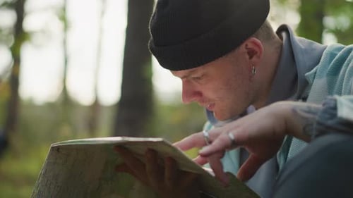 Hiker Examining Map Individual Reviewing Map Amidst Tranquil Woodland in Autumn Young Man with Denim