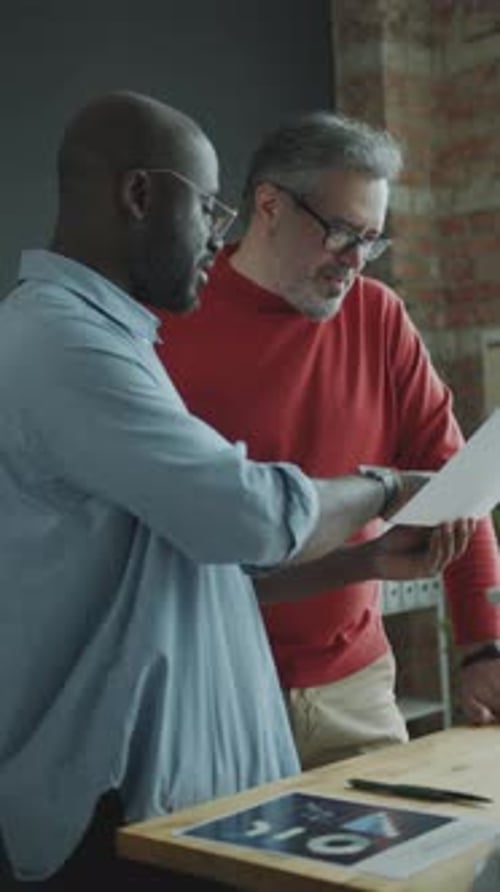 Young Businessman Discussing Document with Senior Manager in Office