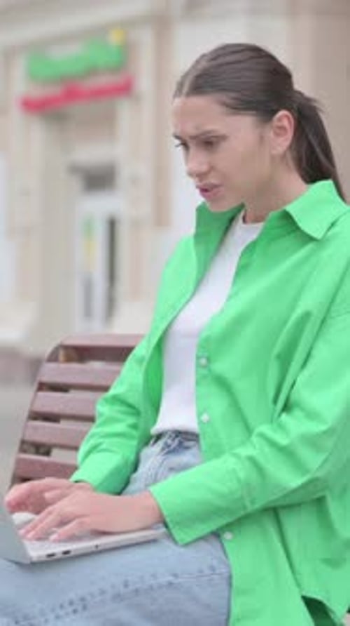 Woman Works on Laptop, Frustrated, Sits on Bench
