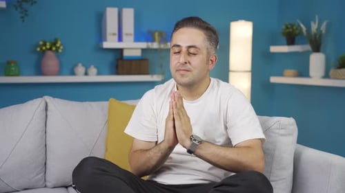 Man Meditating in Cross-Legged Position on Couch