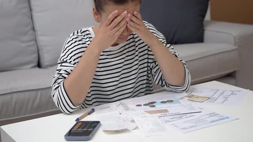 Stressed Woman with Bills at Home