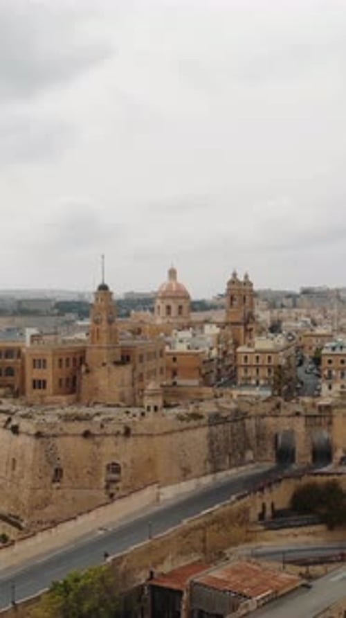 Aerial - senglea basilica rising above the historic three cities malta vertical
