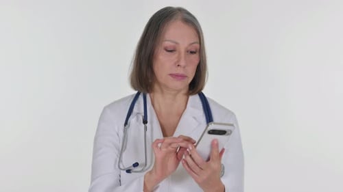Senior Woman Doctor Using Cell Phone in Clinic