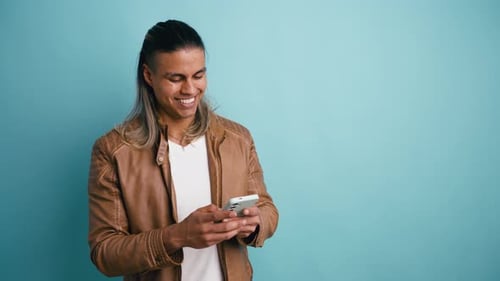 Smiling Handsome Latino Man Using a Smartphone