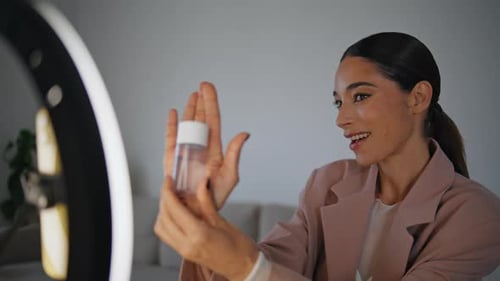 Bloguera parlante mostrando un tutorial de filmación de una mujer de cerca desde el cosmético hasta el teléfono móvil