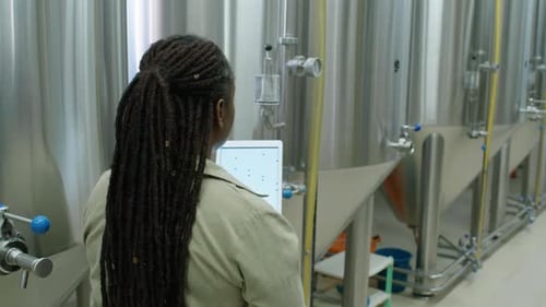 Technicienne surveillant les cuves de fermentation à la brasserie