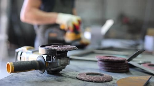 A Metal Grinder and Nozzles on a Table in a Metal Furniture Production Shop