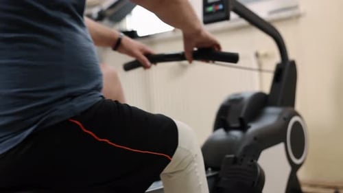 Man Exercising on Rowing Machine Indoors