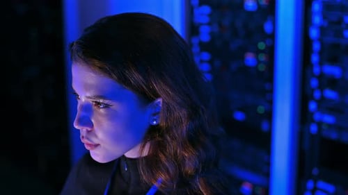 Woman Works in Dark Data Center Server Room