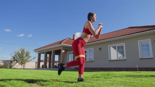 Woman Exercising With Resistance Band in Yard