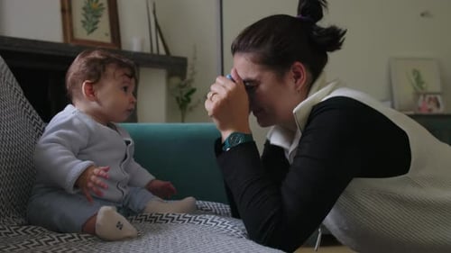 Woman and Baby Play with Toy on Couch