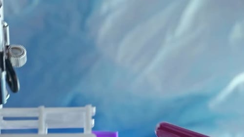 Gloved Hands Hold Blood Vials in Lab