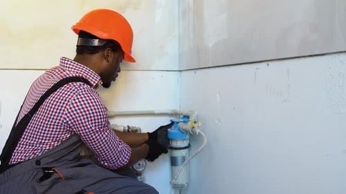 Man in Hardhat Repairs Pipes