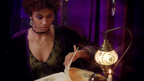 Focused Woman Reads Old Book by Decorative Lamp