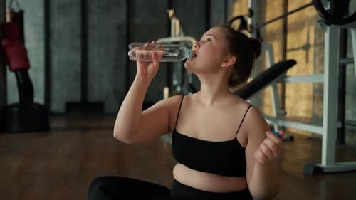 Young Woman Drinks Water After Gym Workout