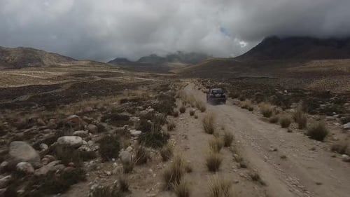 Drone: flies behind a car through a gorge in the mountains of Kyrgyzstan