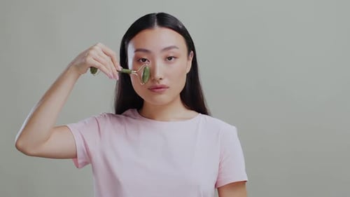 Woman uses facial roller for beauty treatment