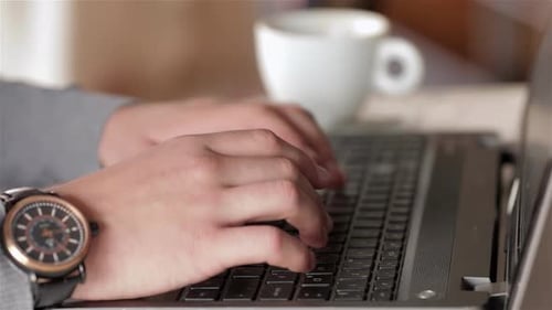 Hands Typing on Laptop, Coffee Cup in Background