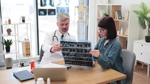Specialist and Patient Posing with CT Scan Picture at Clinic