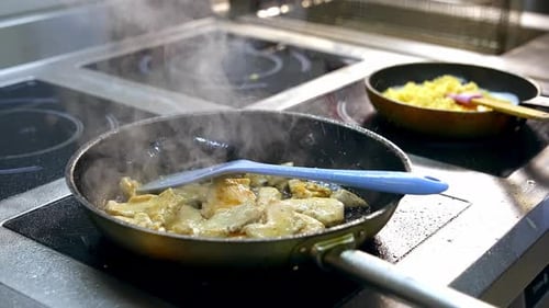 Frying food on iron pan. Chef cooking food in large pan at restaurant