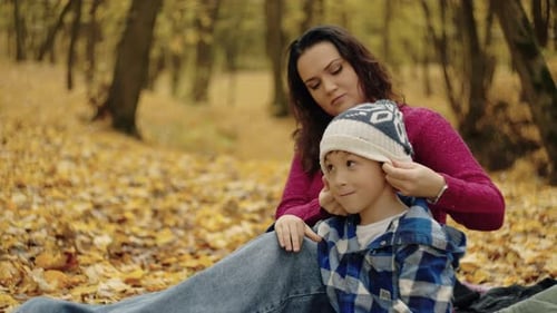 Mutter und Sohn sonnen sich in der Wärme des Herbstes und teilen wertvolle Momente bei einem Picknick