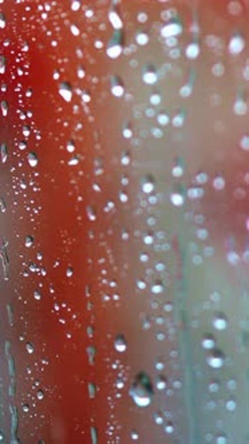 Glass window in a rainy day with drops. Transparent water of raindrops on a glass surface