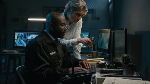 Security Guard Working with Supervisor on Computer