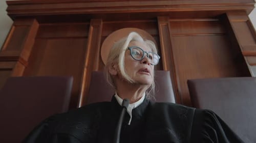 Senior Female Judge Communicating with Litigants during Court Hearing