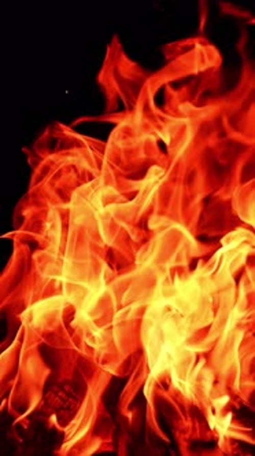 Feuerloder mit roter Flamme. Heißer Kamin, der vor Orangenbrand leuchtet. Vertikales Video