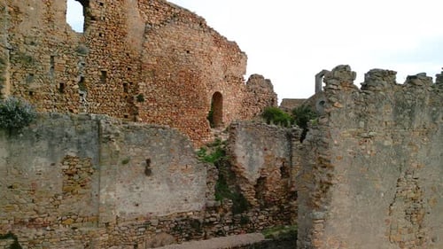 Ruined castle in Europe aerial footage cinematic medieval era Sliding to the left revealing a small