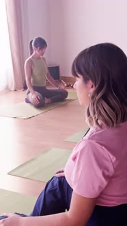 Diverse women meditating in a yoga class studio