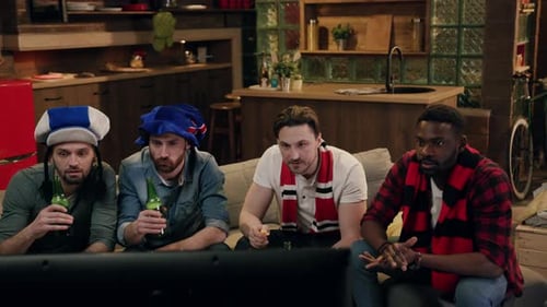 Men Watching Sport Event On TV With Beer