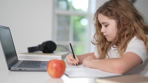 Girl Studies with Laptop and Apple Indoors