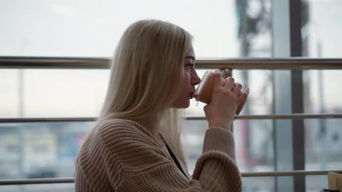 Lady Smiling with Coffee Cup Enjoying Cozy Moment in Modern Cafe