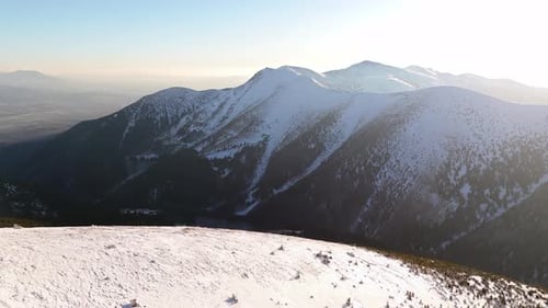 Aerial View of a Winter Mountain Ridge Illuminated By Radiant Sunlight