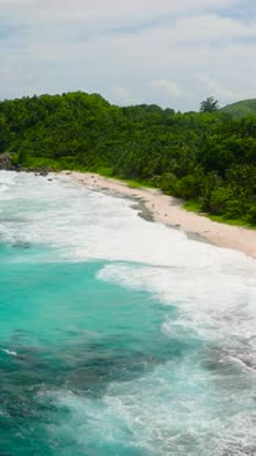 Turquoise Ocean Waves and White Sandy Beach with Green Hills Seychelles Mahe