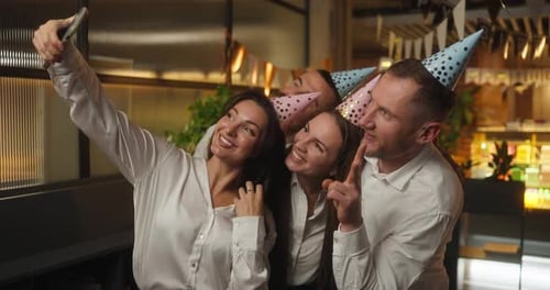 Four Happy Office Workers in Business Clothes Take a Selfie and Rejoice During a Fun Corporate Party