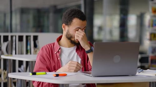 African American Student Takes Off Glasses Feels Tired After Long Work at Laptop in Library Campus