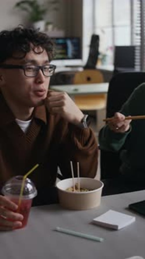 Office Colleagues Eating Lunch and Chatting at Workplace
