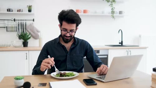 Young Adult Eating Salad at Kitchen Table