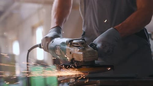 Ein Arbeiter in einer Schwerindustriefabrik für die Herstellung von Metallkonstruktionen. Ein Mann in einem einheitlichen Grinsen
