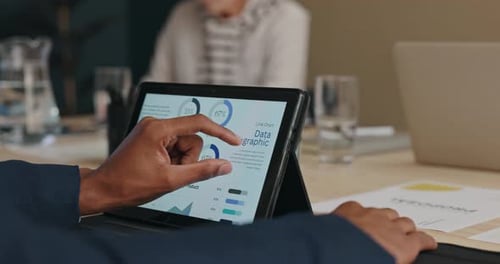 Man Uses Tablet to Present Data in Meeting