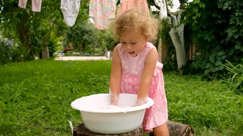 The Child is Washing Clothes in the Garden Selective Focus