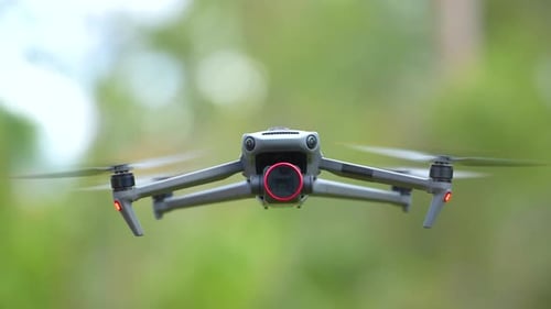 Cuadricóptero con cámara digital y hélices de rotación rápida volando tomando Vídeo y fotografías