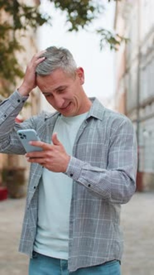 Mature Man Using Smartphone Typing Browsing Loses Becoming Shocked Sudden Lottery Results on Street