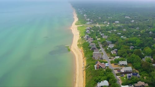 Drone Footage of Beach Houses Beside Sea in Overcast Weather