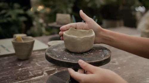 Person Crafting Clay Pot on Pottery Wheel in Workshop