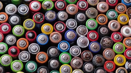 AA Household Alkaline Batteries Were Used Top View on the Background of Used Batteries