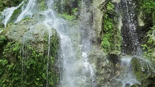 Cascada mágica de montaña, agua cristalina, grandes piedras cubiertas de musgo. La cascada con el